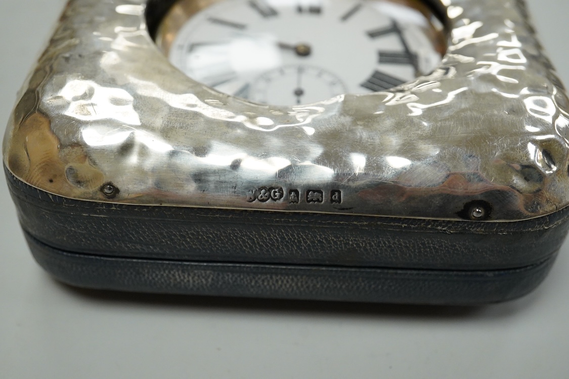 An Edwardian hammered silver mounted travelling pocket watch case, Wilson & Gill, Birmingham, 1903, containing a nickel cased pocket watch.